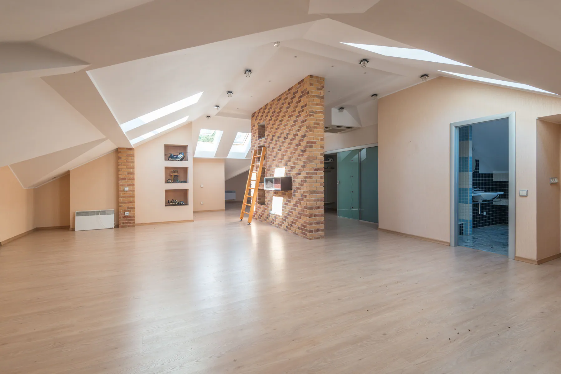 Large empty living room with clean hardwood floors, fireplace, and windows