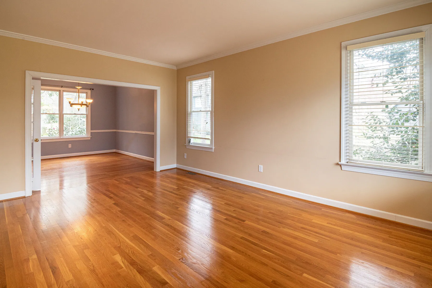 Bright empty living and dining rooms with clean hardwood floors